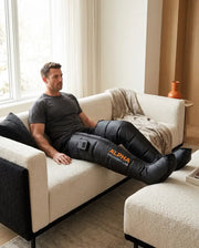 Man using AlphaFlow wireless compression boots at home